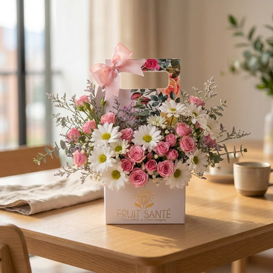 Caja jardinera con flores rosadas y blancas sobre mesa de comedor, flores a domicilio en Bogotá