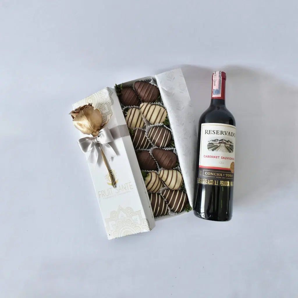 Caja de fresas con chocolate y botella de vino
