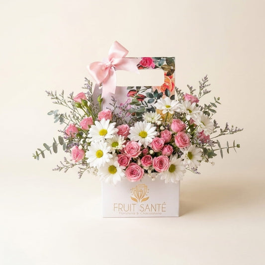 Arreglo Jardín Floral con mini rosas rosadas y margaritas blancas en caja jardinera con moño rosa