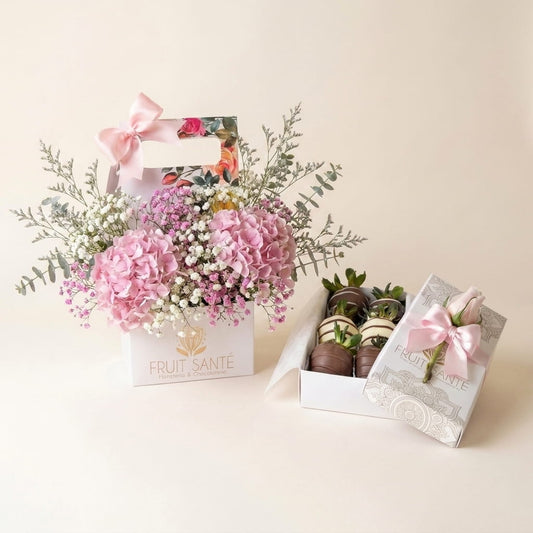 Dúo Jardín Floral con hortensias rosadas en caja jardinera y caja de fresas con chocolate