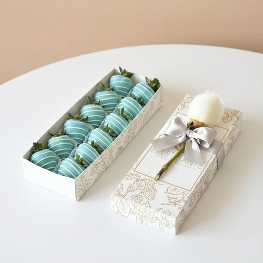 Caja Fruit Santé con 12 fresas azules cubiertas de chocolate y rosa blanca con lazo plateado en empaque premium (Bogotá)