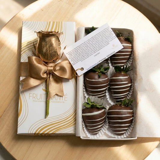 Vista superior de caja premium con fresas con chocolate y rosa pintada en dorado Fruit Santé