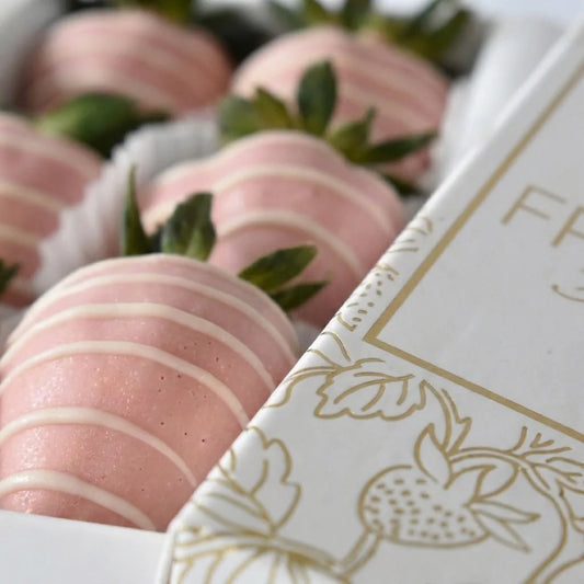Caja de fresas cubiertas con chocolate rosado