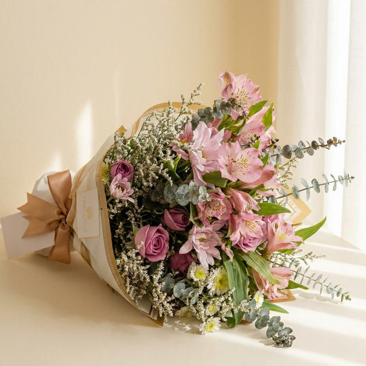 Vista lateral de bouquet de astromelias rosadas y rosas rosa mauve con caspia y eucalipto Fruit Santé
