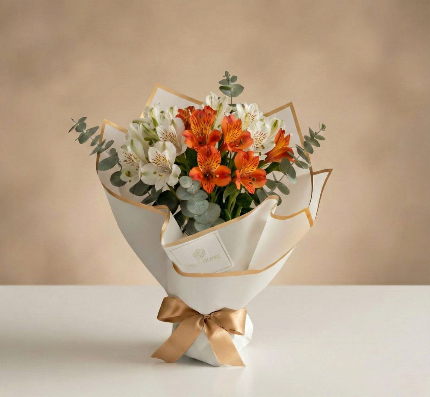 Bouquet de alstroemerias blancas y naranjas con eucalipto en empaque blanco minimalista con lazo dorado – Fruit Santé Bogotá