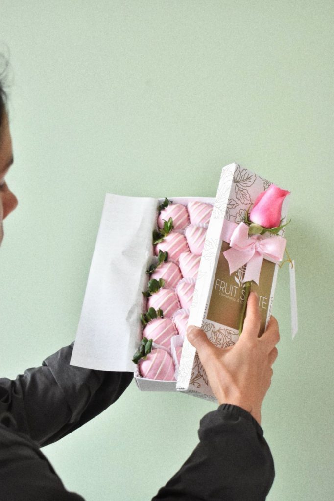 Caja de 12 fresas cubiertas con chocolate rosado y rosa rosada